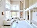Bright living room with high ceilings, a wall of windows, tiled floors and a cozy seating area at 1601 Fairgate Ct, Las Vegas, NV 89117