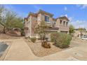 Townhouse exterior featuring desert landscaping with rocks and small bushes and trees at 223 Positive Point St, Henderson, NV 89012