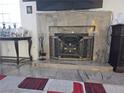 Elegant living room fireplace with a decorative screen, marble surround and hearth, and displayed decor at 2370 Ray Kanel Dr, Las Vegas, NV 89156