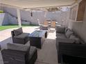 Comfortable covered patio featuring a dining set, fire pit table, and plush seating, perfect for outdoor relaxation at 2370 Ray Kanel Dr, Las Vegas, NV 89156