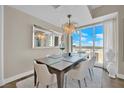 Contemporary dining room features a modern chandelier, a large mirror, a dining table, and city views from the large window at 2700 Las Vegas Blvd # 1803, Las Vegas, NV 89109