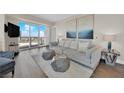 The spacious living room offers modern decor, hardwood floors, a comfortable gray sofa, and a beautiful outdoor view at 2700 Las Vegas Blvd # 1803, Las Vegas, NV 89109