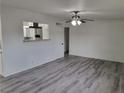 Living room with gray wood-look floors, white walls, and ceiling fan at 310 E Lake Mead Blvd, North Las Vegas, NV 89030