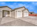 Close-up of a home showcasing a two-car garage, modern door, and neutral color scheme with desert landscaping at 3120 S Torrey Pines Ave, Pahrump, NV 89048