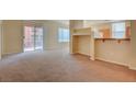 Bright living room featuring beige carpet, a partial wall, a sliding door, and multiple windows at 43 E Agate Ave # 305, Las Vegas, NV 89123
