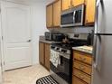 Galley kitchen features stainless steel appliances and wood cabinetry at 5055 W Hacienda Ave # 2175, Las Vegas, NV 89118