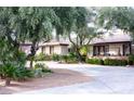 Single-story home with mature trees, desert landscaping, and long concrete driveway at 6540 Tara Ave, Las Vegas, NV 89146