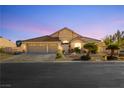 Home exterior showcasing a three-car garage, tile roof, desert landscaping and paved driveway at 6617 Golden Bit Ave, Las Vegas, NV 89131