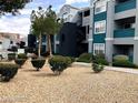Exterior view of a gray and blue apartment building with manicured landscaping and gravel groundcover at 6955 Durango Dr # 3092, Las Vegas, NV 89149