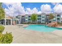Resort-style pool with mature shade tree and ample deck seating surrounded by the condo community at 6955 N Durango Dr # 1074, Las Vegas, NV 89149