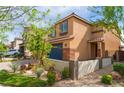 Charming two-story home with desert landscaping featuring a dark garage door and brick-paved driveway at 7322 Dazzle Point St, North Las Vegas, NV 89084