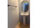 Powder room with a pedestal sink, a round mirror, and tile flooring at 8089 Windmill Villa St, Las Vegas, NV 89139