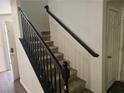 Carpeted stairs with black handrail lead upstairs, next to a closed white door, and the entry at 8226 Royal Lilly Ct, Las Vegas, NV 89139