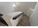 View of the carpeted stairs with white wall and black handrail leading upward from the second floor at 8226 Royal Lilly Ct, Las Vegas, NV 89139