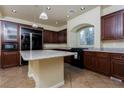 Spacious kitchen features dark cabinetry, granite countertops, stainless steel appliances, and a large island at 8467 Bismark Sapphire St, Las Vegas, NV 89139