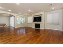 Large living room with fireplace, wood floors, ceiling fan and abundant natural light from multiple windows at 8467 Bismark Sapphire St, Las Vegas, NV 89139