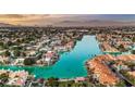 Breathtaking aerial view of luxury waterfront homes surrounding a serene blue lake at 9005 Feather River Ct, Las Vegas, NV 89117