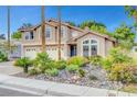 Beautiful two-story home with three-car garage, tiled roof, and desert landscaping at 950 Eagle Mountain Dr, Las Vegas, NV 89123