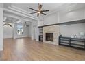 Living room features a stone fireplace, ceiling fan, built-in shelves, and wood floors at 10537 Shoalhaven Dr, Las Vegas, NV 89134