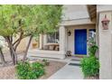 Inviting front porch with bench seating, a blue door, and a well-maintained garden at 10657 Medicine Bow St, Las Vegas, NV 89183