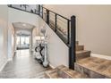 Elegant entryway featuring hardwood floors, staircase with black railings, and modern decor at 10936 White Alder Pl, Las Vegas, NV 89138