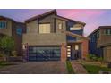 Stunning two-story home with a modern garage door, and stone accents, captured during a vibrant sunset at 10936 White Alder Pl, Las Vegas, NV 89138