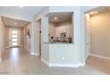 Bright hallway with tile flooring leading to a wet bar, featuring white cabinetry and granite countertops at 11161 Black Fire Opal Dr, Las Vegas, NV 89138
