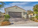 Beautiful single-story home with a tile roof, stucco exterior, and brick driveway leading to a spacious two-car garage at 130 Mountain Cedar Ct, North Las Vegas, NV 89031