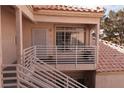 View of front door with landing & railing plus the tile roof above and partial exterior wall at 1900 N Torrey Pines Dr # 225, Las Vegas, NV 89108