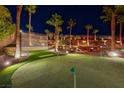 Backyard putting green with artificial turf, perimeter landscaping, and outdoor lounge area at 2064 Poetry Ave, Henderson, NV 89052