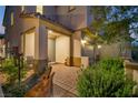 Inviting covered entrance with seating, decorative landscaping, and exterior lighting at 27 Parco Fiore Ct, Henderson, NV 89011
