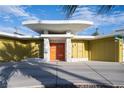 Striking mid-century modern home with an orange door, stone accents, and unique architectural details at 3586 Spencer St, Las Vegas, NV 89169