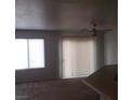 The living room features a ceiling fan, carpeted floors and lots of light from the large sliding glass doors at 4732 Lone Grove Dr, Las Vegas, NV 89139