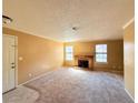 Cozy living room with fireplace, neutral carpet, and natural light from large windows at 5576 W Rochelle Ave # 38B, Las Vegas, NV 89103