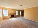 Bright living room featuring a brick fireplace, soft carpet, and ample natural light at 5576 W Rochelle Ave # 38B, Las Vegas, NV 89103