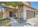 Inviting home exterior showcasing the entrance, front yard, and attached two-car garage at 6031 Colonial Oak Ct, North Las Vegas, NV 89031