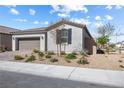 Charming single-story home with a two-car garage and desert landscaping in front yard at 6033 Torciano St, North Las Vegas, NV 89081