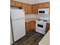 Kitchen featuring white appliances, wood cabinetry, and vinyl flooring at 6425 Extreme Shear Ave # 101, Henderson, NV 89011