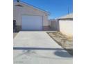Detached garage with a concrete driveway offers convenient parking and additional storage space at 664 Sky Rd, Indian Springs, NV 89018