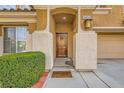 Close up of the decorative wooden front door with a covered front porch and desert landscaping at 6655 Little Owl Pl, North Las Vegas, NV 89084