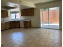 Kitchen with sliding doors to the back, tile counters, and wooden cabinets at 7732 Blackbird Ave, Las Vegas, NV 89145