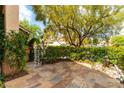 Private courtyard featuring stone pavers, mature landscaping, an iron gate and a soothing water feature at 812 Eaglewood Dr, Las Vegas, NV 89144