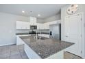 This kitchen features an island with a granite countertop, white cabinets, and stainless steel appliances at 9871 Magnus Ct, Las Vegas, NV 89178