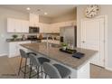 Modern kitchen with white cabinetry, granite countertops, stainless steel appliances, and kitchen island with bar stool seating at 9871 Magnus Ct, Las Vegas, NV 89178