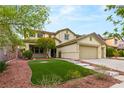 Charming two-story home with lush lawn and neatly arranged garden beds at 10501 Haywood Dr, Las Vegas, NV 89135