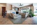 Cozy living room with plush reclining chairs, a fireplace, and large windows offering bright, natural light at 10576 Refugio St, Las Vegas, NV 89141