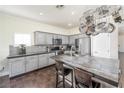 Bright kitchen featuring stainless appliances, gray cabinets, tiled backsplash, and spacious island with bar stool seating at 10633 Tinta Ln, Las Vegas, NV 89144