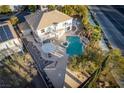 Aerial shot of a backyard oasis with a sparkling pool, jacuzzi, pergola and lush landscaping creating a private retreat at 10725 Bernini Dr, Las Vegas, NV 89141