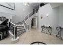 Grand foyer featuring a curved staircase, tile flooring, high ceilings and elegant decor, welcoming you into this beautiful home at 10725 Bernini Dr, Las Vegas, NV 89141