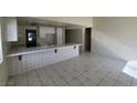 Spacious kitchen with white cabinets, a long tile countertop, and tile floors at 1673 Caliente Ct, Las Vegas, NV 89119